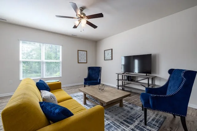 living room with blue chairs  and yellow couch